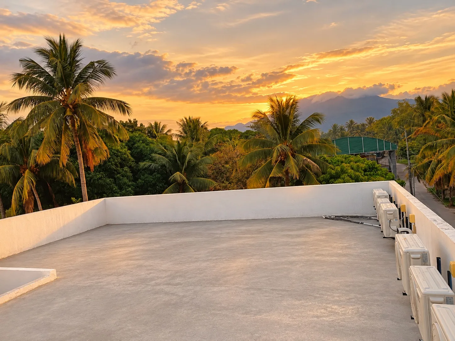 Brownhouse rooftop in Bacong, Negros Oriental: open terrace with coconut palms and mountain at golden hour